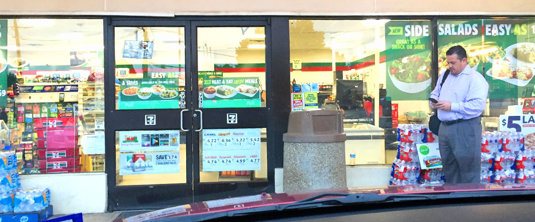 man on phone outside 7-11 convienience store