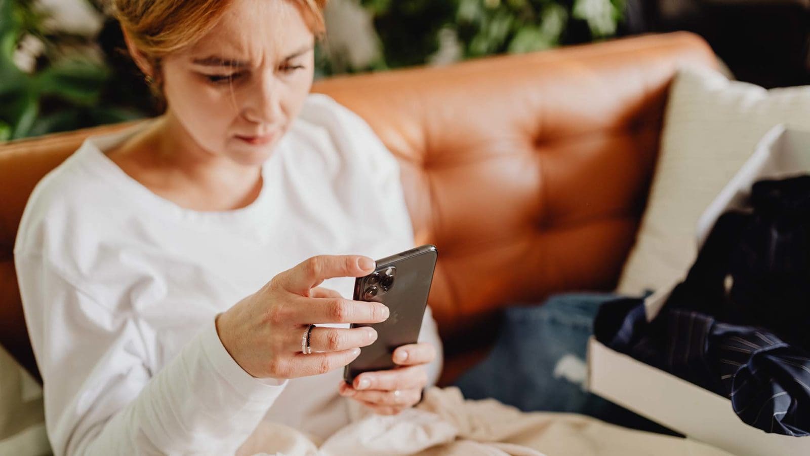 woman on couch using her phone