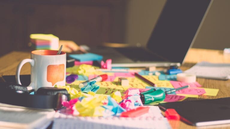 Crumpled sticky notes and mug on table