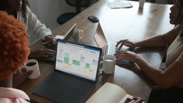 People sitting around a conference table with computers