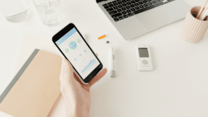 Person holding phone by glucose monitor
