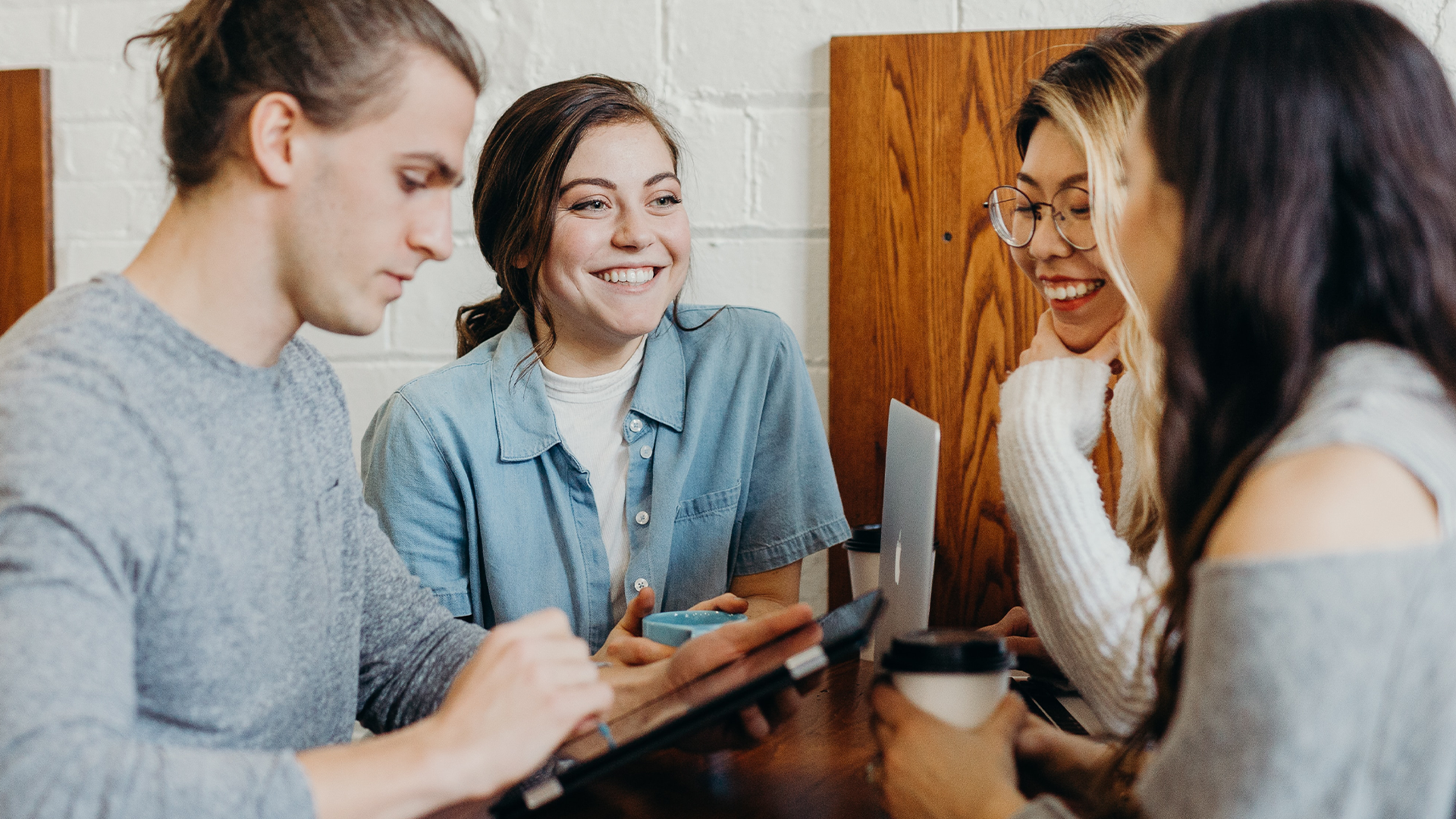 Group of four people talking while on iPad