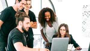 Group of people standing around a computer